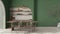 Modern dining room interior in country apartment, cream and green tones, craft wooden table, rattan chairs, molded concrete walls