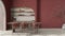 Modern dining room interior in country apartment, cream and red tones, craft wooden table, rattan chairs, molded concrete walls