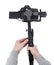 Modern dslr camera on 3-axis gimbal stabilizer in male videographer hands isolated on white