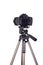 Modern dslr camera with blank screen on tripod isolated on white