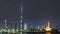 Modern Dubai city skyline timelapse at night with illuminated skyscrapers over water surface