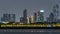 Modern Dubai city skyline timelapse at night with illuminated skyscrapers over water surface