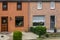 Modern dutch terraced house exterior with gardens, plants behind the windows, homes in a dutch village