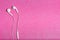 Modern earphones on the pink background