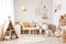 Modern eco-friendly kids room with wooden accents, colorful toys, and a poster mockup in Scandinavian style