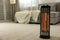 Modern electric halogen heater on floor in living room interior