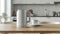 a modern electric kettle sitting beside a cup on a wooden table in a light-filled, minimalist kitchen, portraying the