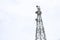 Modern electric pillar with communication equipment on white cloud sky. Communication tower with antennas