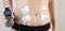 A modern electronic acupuncture for burning belly fat and strengthening muscles on the girl`s body, close-up