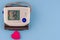 Modern electronic blood pressure monitor with red heart on a blue background