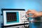 Modern electronic oscilloscope on abstract background