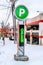 Modern electronic parking sign on snowy landscape outside commercial building