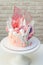 Modern elegant pink cake with caramel, white chocolate, waffle paper, meringues and french macaroons decoration
