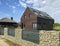 Modern energy efficient house with solar panels and gabion fence