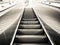 Modern escalator vertical transportation in the form of a moving staircase in black and white color.