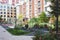 Modern european residential apartment complex yard territory, multi-story house buildings with playground and benches,