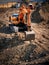 A modern excavator digs the ground to replace pipes and sewer wells