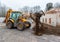 The modern excavator performs excavation work on the construction site. Front view of a digger bucket of digging ground as a part