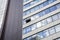 Modern facade of office building with glass and steel. One open window. Reflection sky and clouds. Exterior of futuristic business