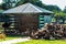 Modern farm with a beautiful lawn and a firewood shed. the logs lie neatly under the canopy. near a pile of ribbed wood