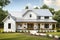 modern farmhouse exterior with fresh paint, sleek metal roof and wrap around porch