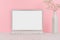 Modern fashion workplace - silver laptop with blank screen, white stationery on soft pink background.