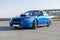 a modern fast race sport blue car on the track on summer practice day