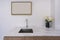 Modern faucet and wash basin sink on white marble counter with wooden photo frame space for advertising, yellow orchid flower
