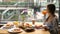 Modern female businesswoman eat breakfast buffet in urban cafe with city life