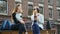 Modern female students use mobile phone, sitting on bench in campus park before lessons. University concept