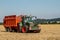 Modern Fendt tractor pulling orange trailer