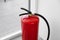 Modern fire extinguisher near window, closeup