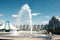 A modern fountain in the city park on the summer playground. Cascade system of urban fountains in the main square on a sunny