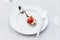 Modern French food: Diced watermelon with white crush cheese served in silver spoon on white plate with cutlery as appetizer