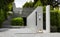 Modern front garden with concrete embankments and gravel in geometric arrangement next to artistically trimmed plants, made with