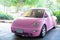 Modern fun pink small car. Photo of a modern funky pink car parked