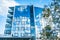Modern futuristic glass apartment house reflecting the blue sky in windows, Kouvola, Finland