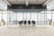 Modern glass wall conference room with black chairs and table in spacious office hall with wooden floor and city skyscrapers view