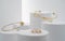 Modern golden bracelets and ring on white cylinders setup