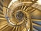 Modern, golden spiral staircase which gives an hypnotic view