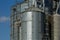 Modern grain terminal. Metal tanks of elevator. Grain-drying complex construction. Commercial grain or seed silos at