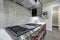 Modern gray kitchen features steel stove with a hood