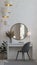 Modern gray velvet chair, desk, round mirror and table lamp and home accessories and chandelier
