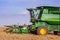 A modern green combine harvester is busy harvesting wheat on a wheat farm in the Overberg region of South Africa