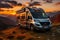 Modern grey camper parked in the mountains at sunset, with vibrant colors painting the sky