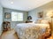 Modern guest bedroom with beige bedding, and carpet.