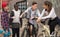 Modern guys and a girl chatting in the yard and holding bikes