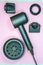 Modern hair dryer with various nozzles on a pink background. The concept of beauty, fashion, makeup, cosmetics.
