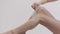 Modern hair removal. Close up of unrecognizable caucasian lady caressing smooth skin of her perfect legs with feather