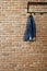 Modern hallway loft interior with denim coat on hanger against brick wall